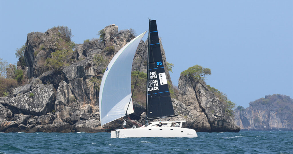 Stealth 11.8 Boreas under spinnaker near limestone islands Bay Regatta Thailand
