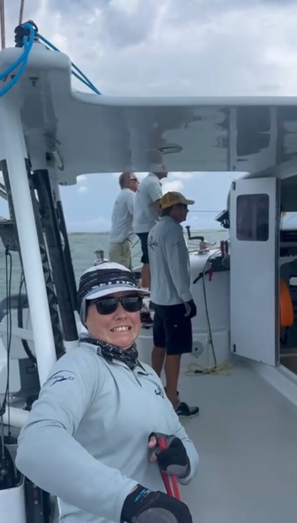 Crew member smiling while trimming lines on Stealth performance catamaran Cut Snake during Moreton Bay Multihull Regatta 2026