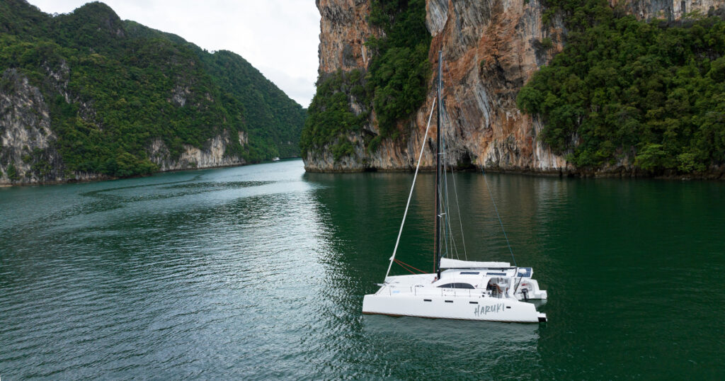 Aerial drone image of Stealth catamaran Haruki anchored near Ko Hong cliffs in Thailand