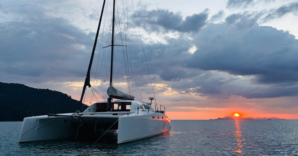 Stealth catamaran Haruki anchored at sunset near Ko Tarutao Thailand